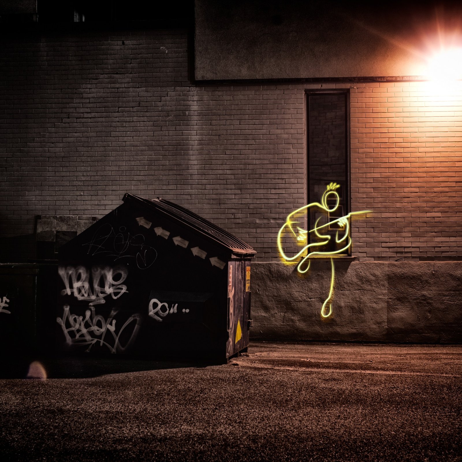 A guitarist drawn in yellow neon light against a brick wall